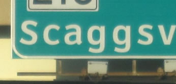 An image of a portion of a guide sign showing a single line of legend with inadequate space between the legend and the outer edge of the sign.